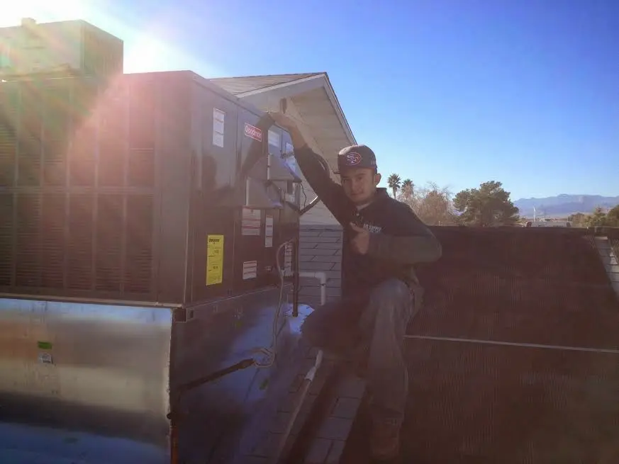 HVAC technician performing AC Tune-Up on a rooftop unit in Spring Hill